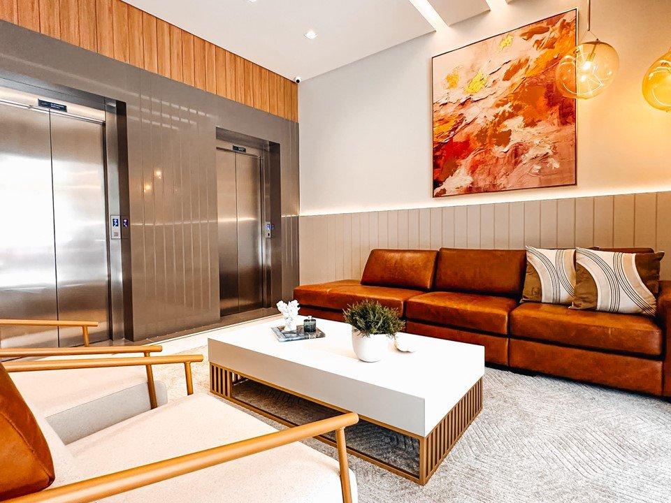 Hall de entrada do Long Beach Residence, com elevadores e lounge decorado